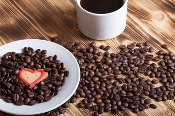 Coffee beans and coffee in white cup on wooden table for backgro