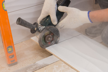 construction work laying tile on the wall close up