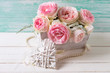 Pink roses flowers  in wooden box and  decorative heart  on whit