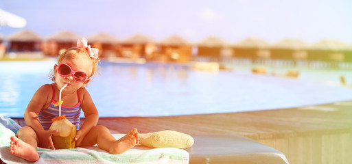 Wall Mural - little girl drinking coconut cocktail on beach