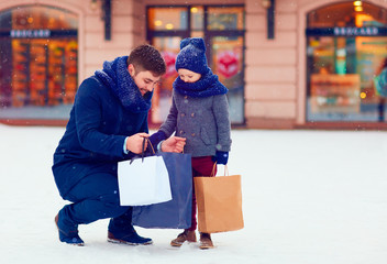 father and son on winter shopping in city, holiday season