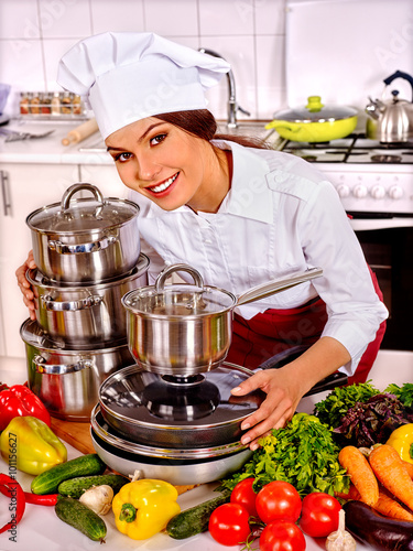 Nowoczesny obraz na płótnie Happy female shef cooking in many pots at kitchen. 