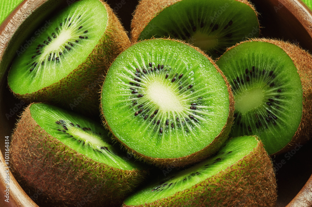 Juicy ripe kiwi fruit in wooden bowl - obrazy, fototapety, plakaty 