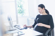 © JGI/Tom Grill/Blend Images - Pregnant Japanese businesswoman using computer