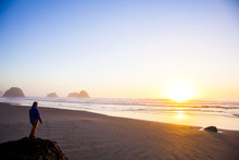 Caucasian Woman Overlooking Sunrise On Beach