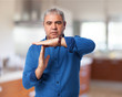 © asierromero - portrait of a mature man dong a time out gesture