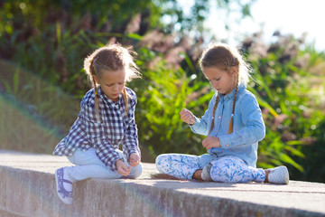 Wall Mural - Little adorable girls at warm sunny autumn day outdoors