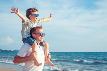 Wall Mural - Father and son playing on the beach at the day time.