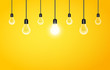 Hanging light bulbs with glowing one on a yellow background, copy space. Vector illustration for your design.