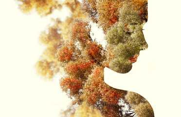 Double exposure portrait of young woman and autumn trees.