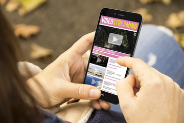woman with video streaming phone in the park