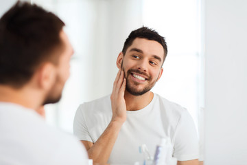 Wall Mural - happy young man looking to mirror at home bathroom