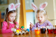 © MNStudio - Two little sisters painting colorful Easter eggs