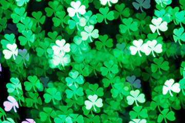 Wall Mural - Blurring lights bokeh background of green clovers. Happy Saint Patrick's Day Background