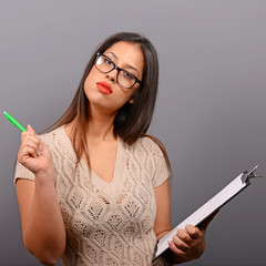 Portrait of businesswoman holding notebook against  gray backgro