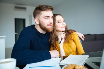 Poster - Happy couple sitting at the table with bills