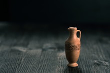 Small Clay Jug On A Wooden Table
