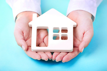 Sticker - Female hands holding house on turquoise background