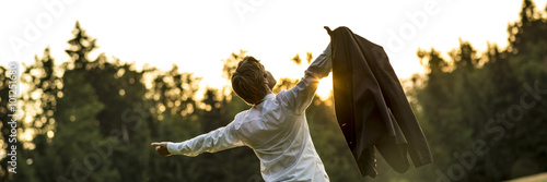 Fotomural Young businessman holding his jacket with arms spread widely as