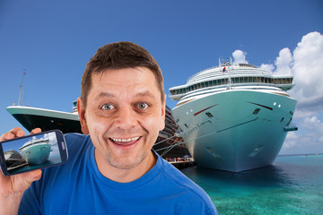 Man in front of two cruise ships with photos precisely this on his mobile phone