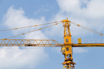 Crane over unfinished tower on construction site.