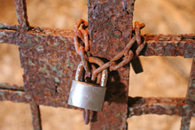 Padlock With The Chain And The Closed Gate Of Ancient Prison