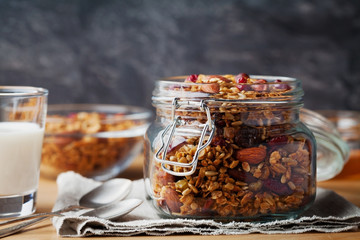 Wall Mural - Homemade granola in jar on rustic table, healthy breakfast of oatmeal muesli, nuts, seeds and dried fruit