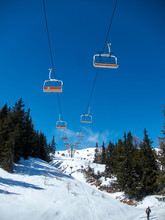 Chairlift With Orange Seats On Blue Sky