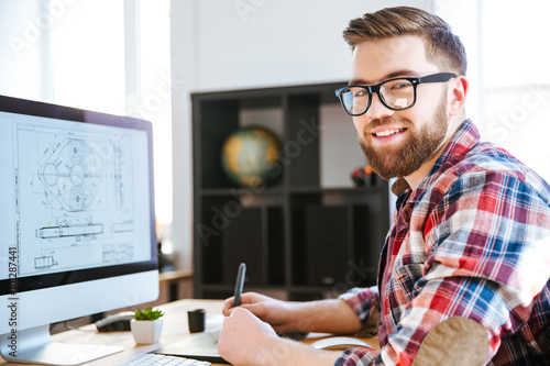 Fotografie, Obraz Happy designer drawing blueprint on computer using pen tablet