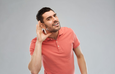 man having hearing problem listening to something