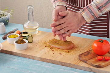 Man cooking spicy chicken on the home kitchen