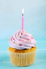 Poster - Tasty pink cupcake decorated with candle on light background