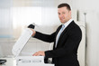 © Andrey Popov - Businessman Using Photocopy Machine In Office