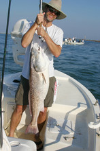 Happy Fishermans Holds Up Big Redfish