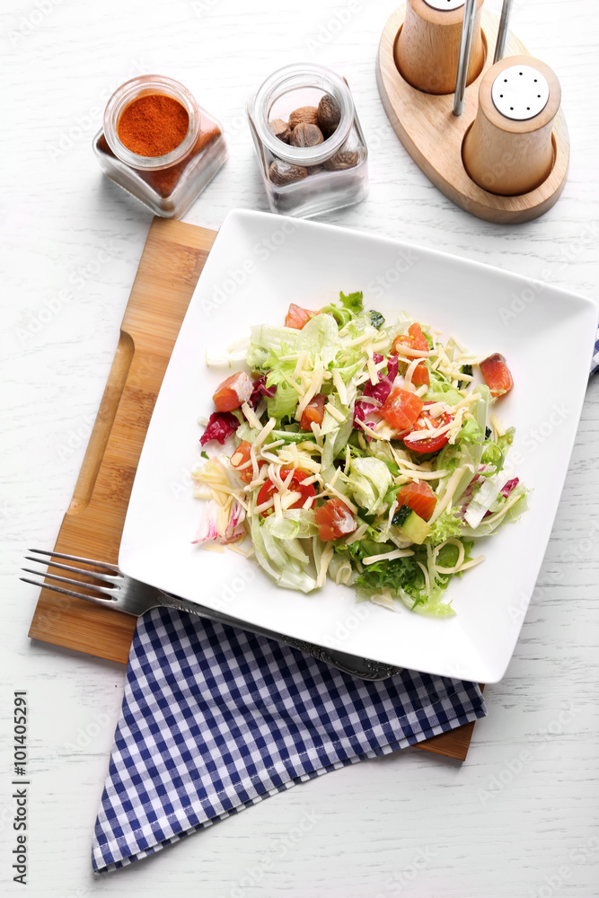 Tasty salmon salad on wooden table background