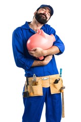 Wall Mural - Plumber holding a piggybank