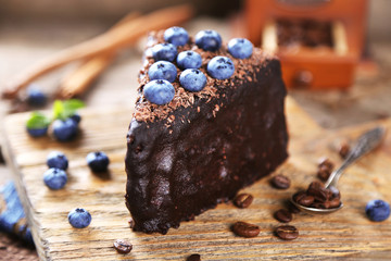 Sticker - Chocolate cake with chocolate cream and fresh blueberries on plate, on wooden background