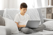 © Africa Studio - Boy using laptop on a sofa at home