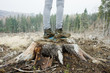 Muddy female boots standing on a stump in winter forest