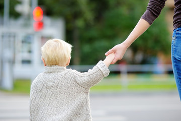 Mother and toddler crossing the street on the crosswalk