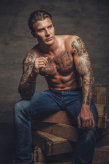 Wall Mural - Shirtless tattooed guy in denim jeans.