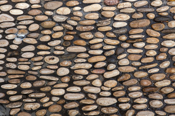 Cobbled pavement made of river rounded pebbles. Background textu