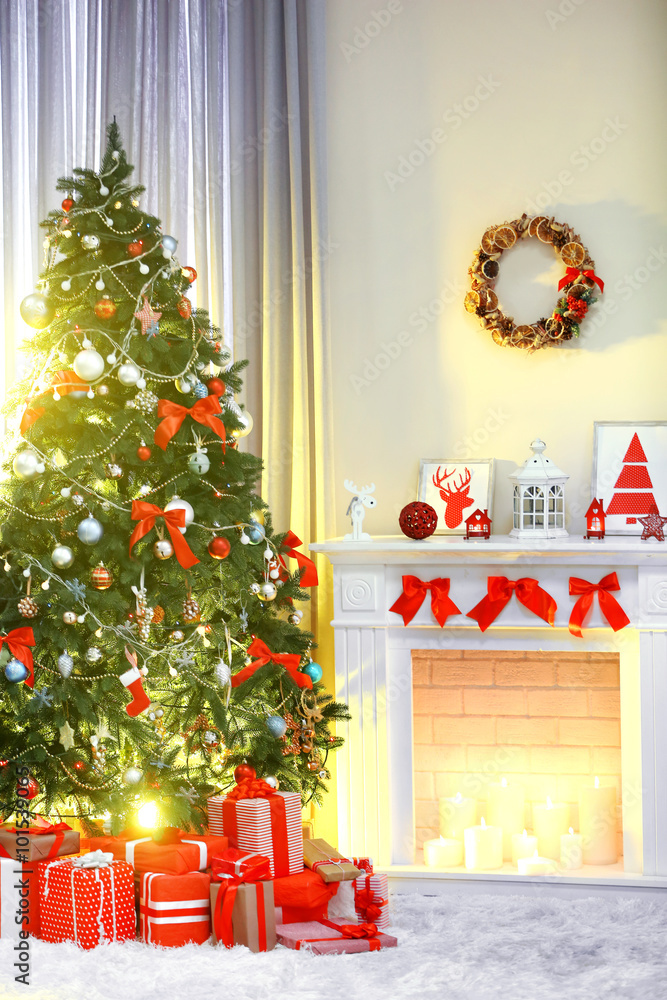 Christmas tree with presents near the fireplace in a room