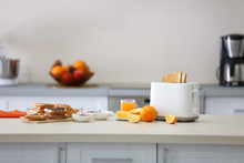 Toaster With Dishes, Sandwiches And Oranges On A Light Kitchen Table