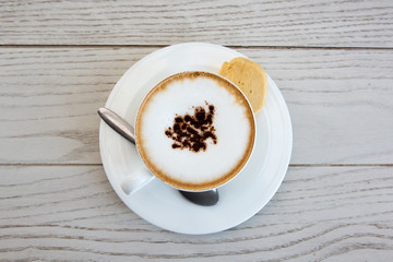 Wall Mural -  cappuccino coffee cup on wood table at coffee shop