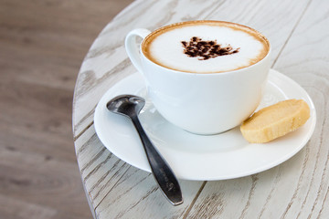 Wall Mural -  cappuccino coffee cup on wood table at coffee shop