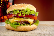 Big Cheeseburger With Glass Of Cola On Red Spotlight