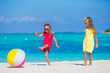 © travnikovstudio - Little adorable girls playing with ball on the beach