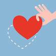 Hand picking up red heart on blue background