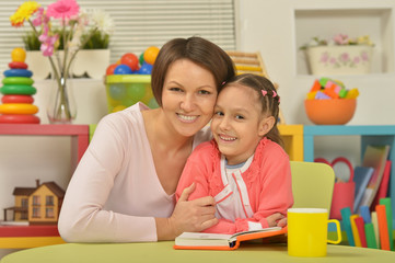 Wall Mural - Daughter and mother reading the book